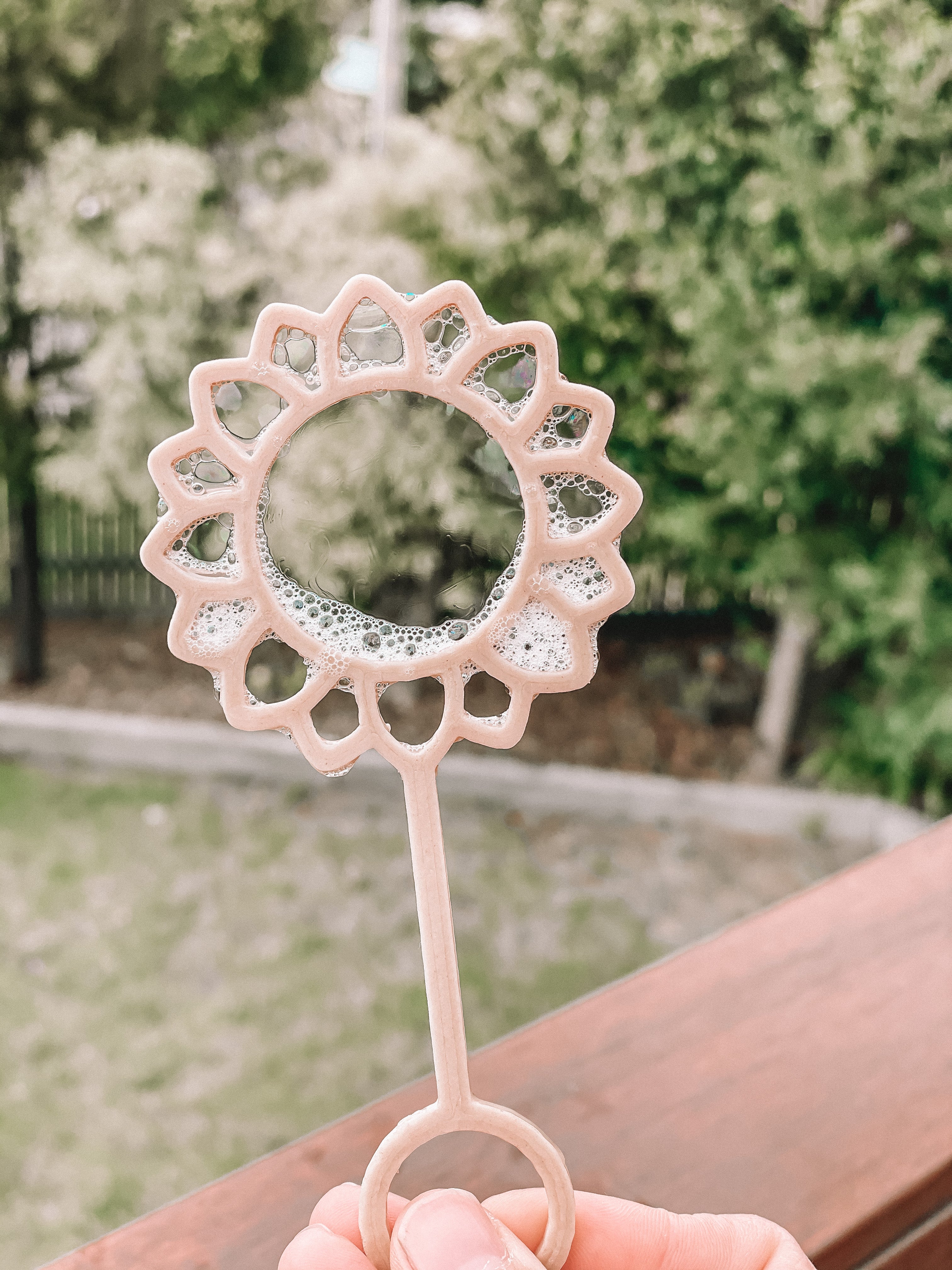 Young child with Sunflower shaped bubble wand blowing bubbles. Australian made, all natural bubble wand which is biodegradable. Spark your child’s imagination with nature toys.