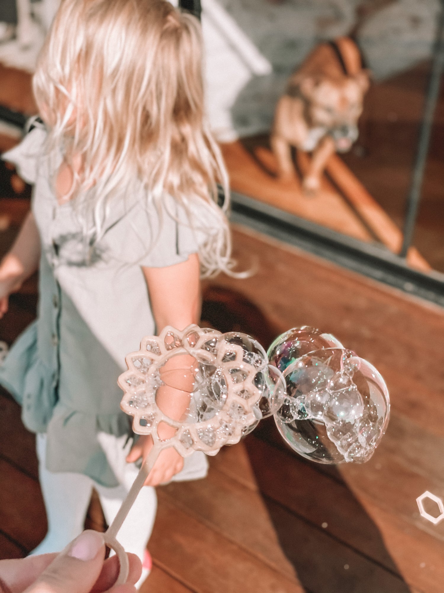 Young child with Sunflower shaped bubble wand blowing bubbles. Australian made, all natural bubble wand which is biodegradable, from Kinfolk Pantry.